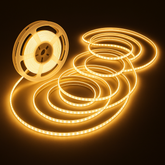 Spool of LED strip light with illuminated strip on a dark background